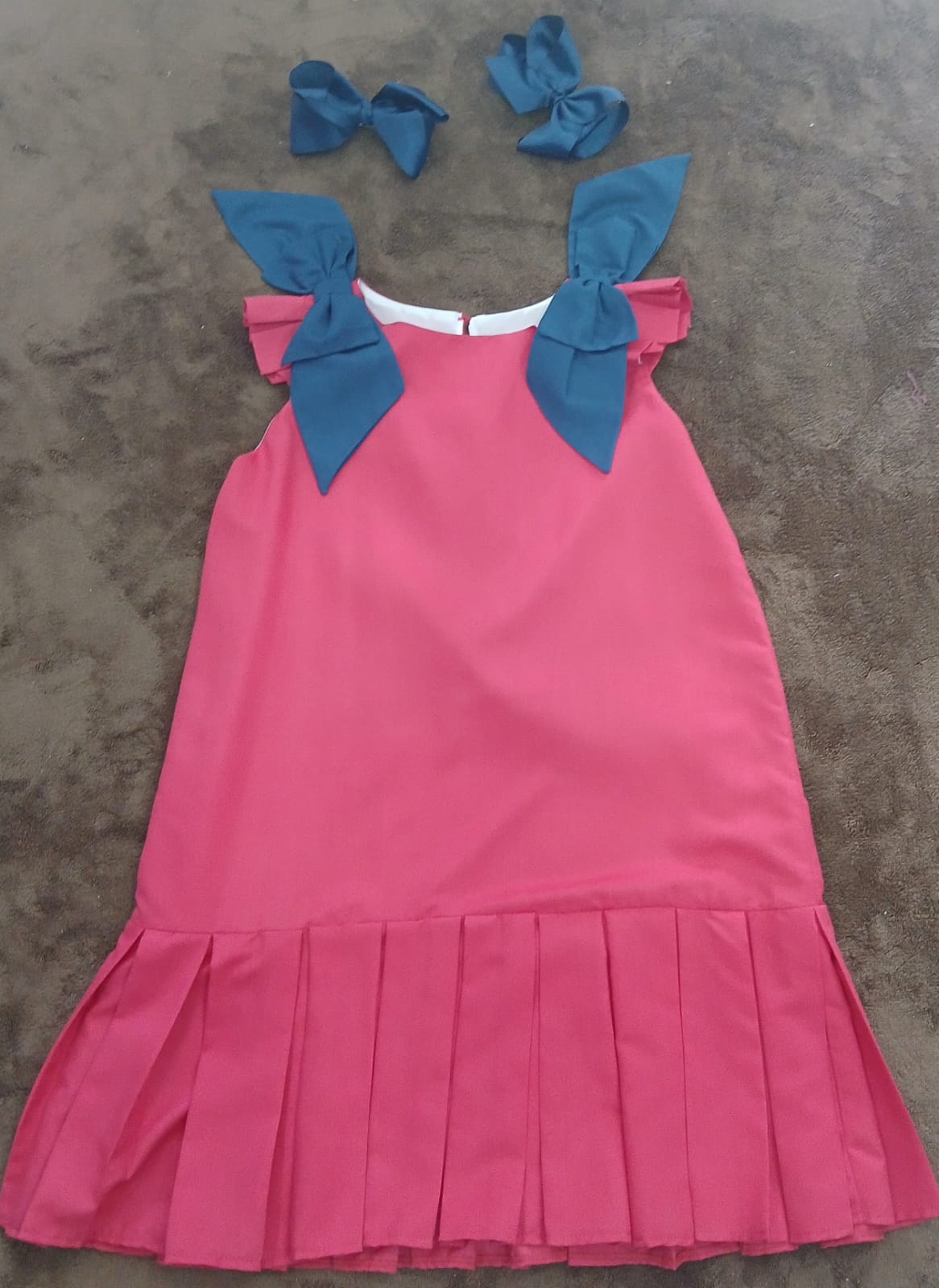 Vestido Rosado con Falda Plisada y Lazos Azules